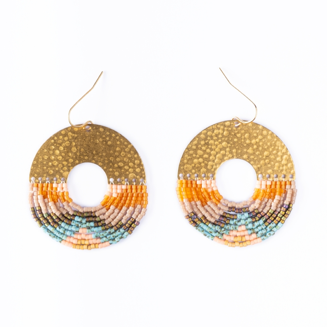 Pair of beaded earrings with gold, orange, and blue design on a white background