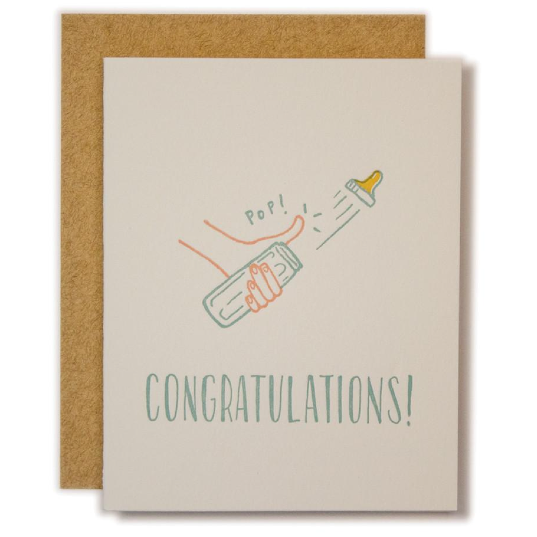 A congratulations baby shower card with a kraft envelope. The card is cream-colored with a hand-drawn illustration of a hand popping a bottle labeled 'POP!' and the text 'CONGRATULATIONS!' in a greenish-teal font.