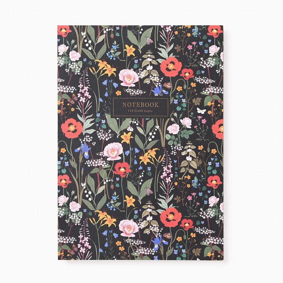 The front cover of a notebook. The notebook has a dark background with a floral inspired pattern featuring flowers on a long stems with leaves and a small box that has "notebook" and "144 blank pages" written in it. Shown on a white background