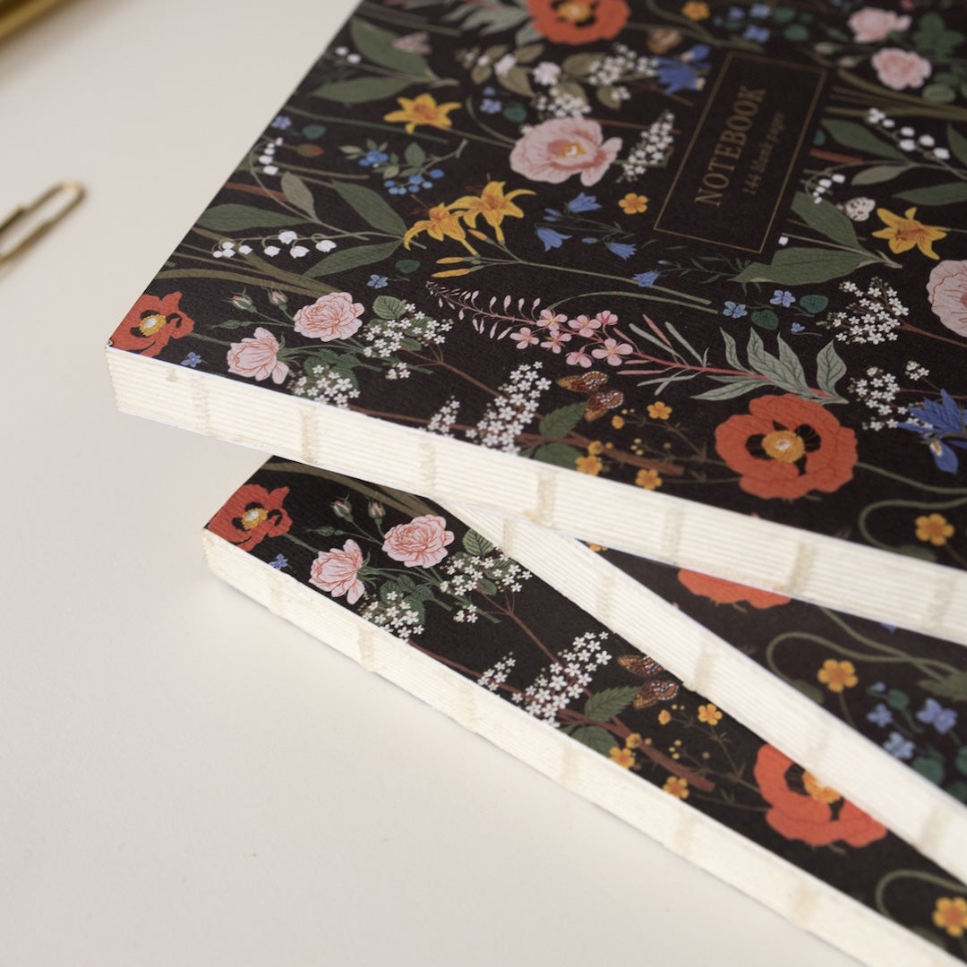 A stack of 3 notebooks highlighting the sewn spine