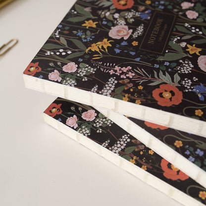 A stack of 3 notebooks highlighting the sewn spine