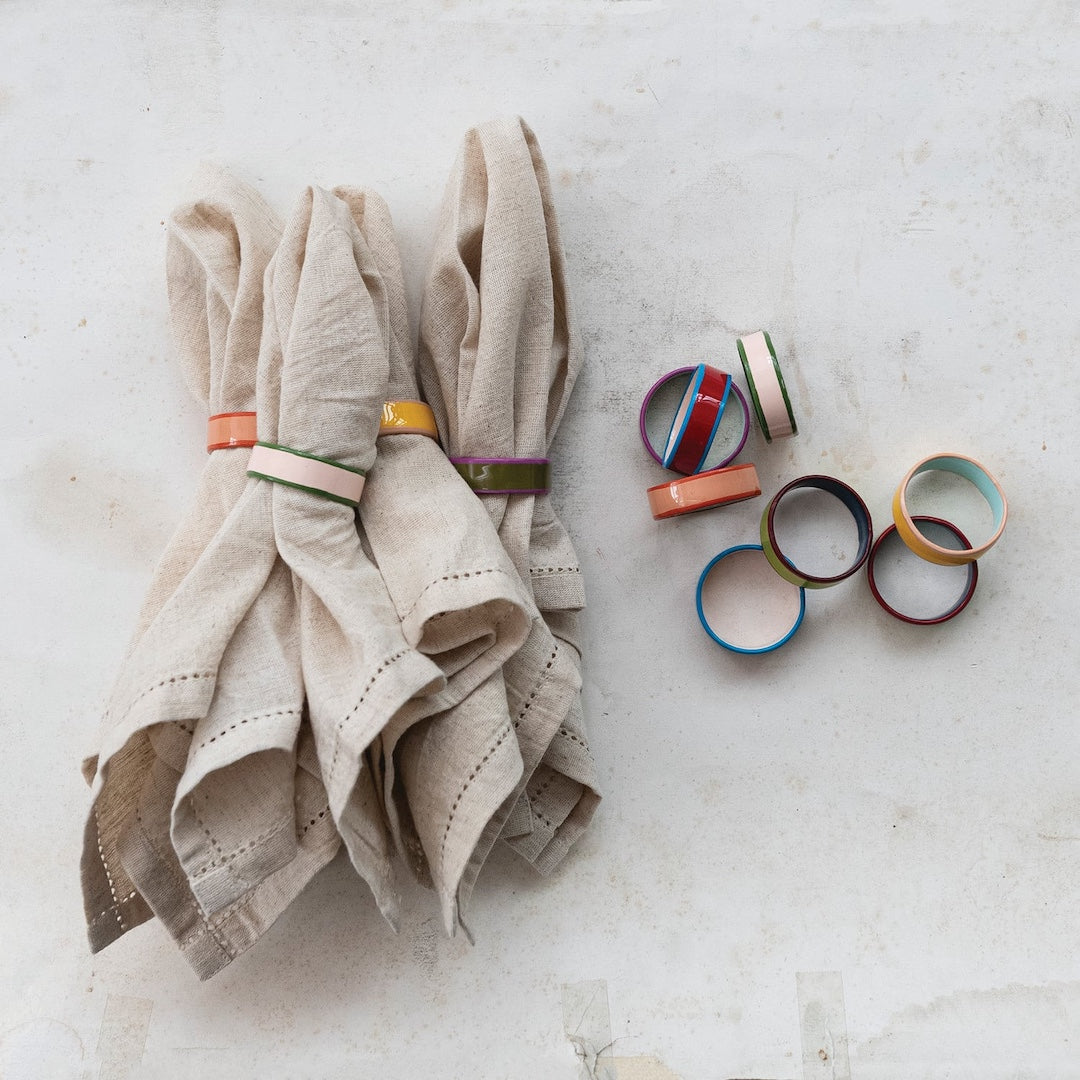 Beige napkin with colorful napkin rings on a light gray surface