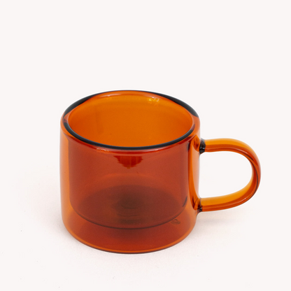 amber double walled espresso cup with handle on a white background