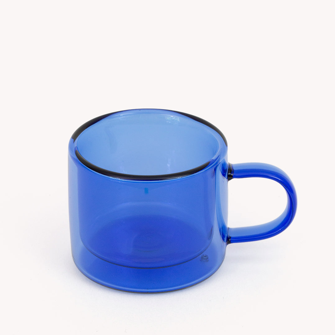blue double walled espresso cup with a handle on a white background