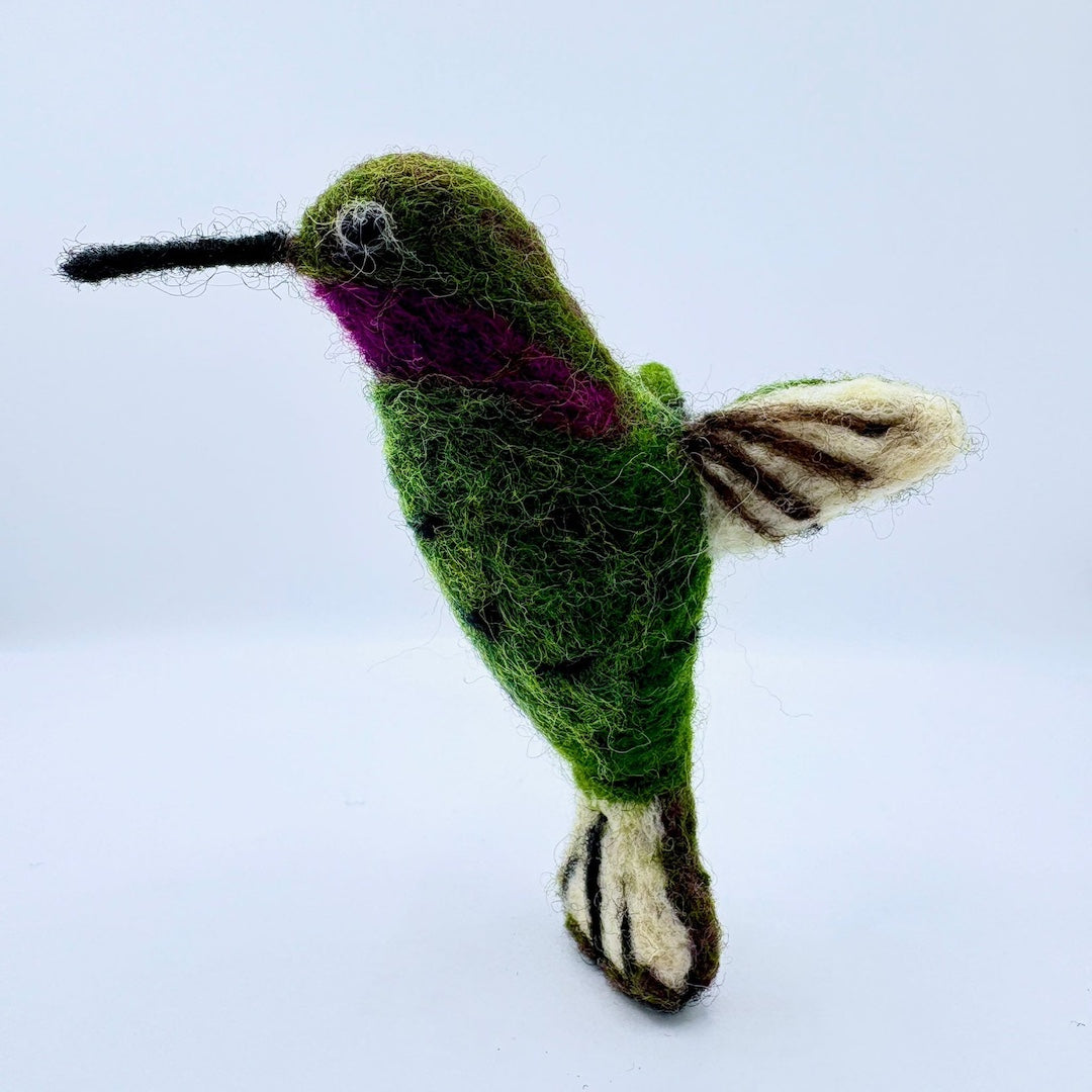 Felted green hummingbird on a light blue background