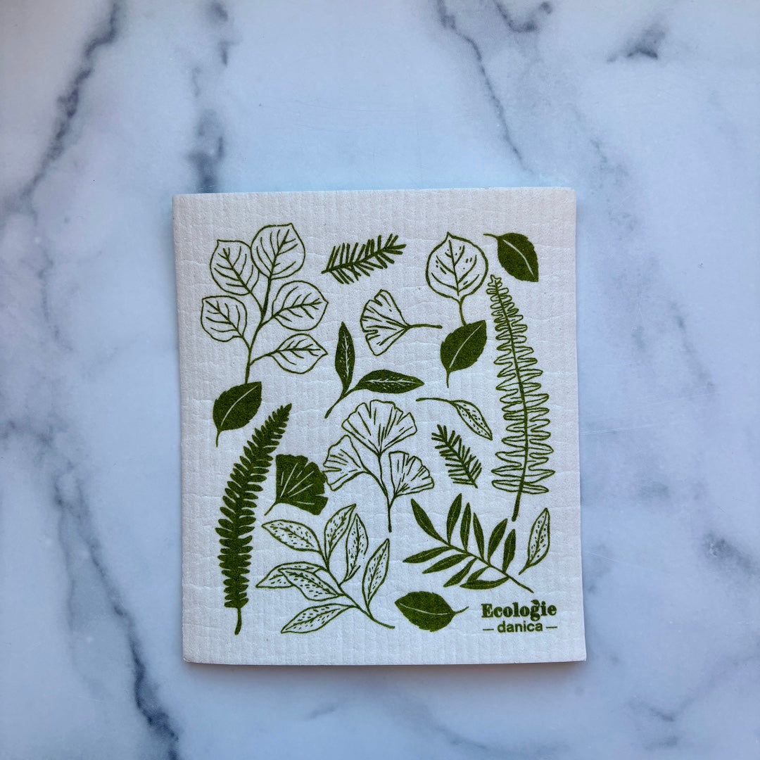 white swedish dish cloth with leaf illustrations on it
