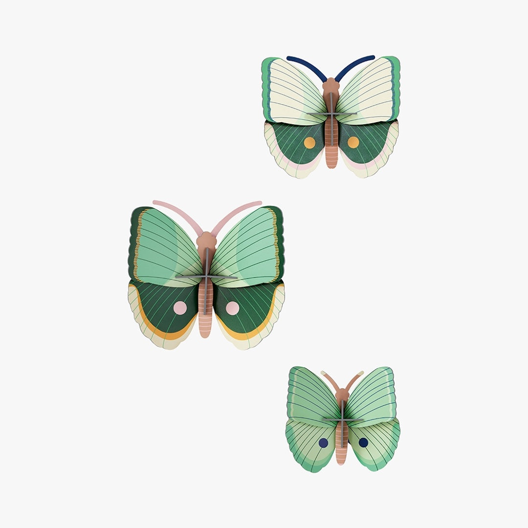Three green butterfly wall hangings on a white background