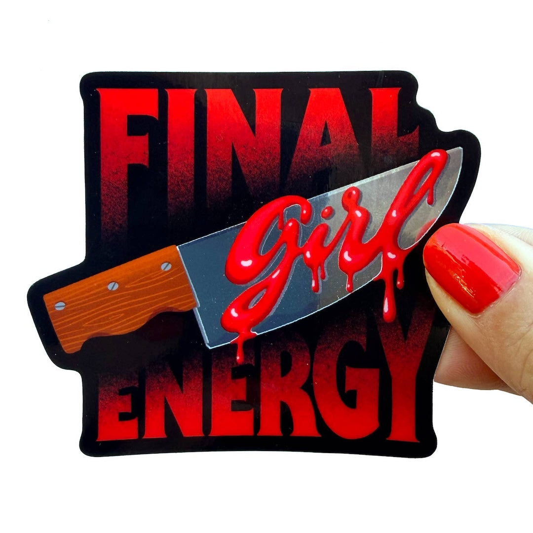A die-cut sticker featuring the text 'FINAL GIRL ENERGY' in red and black, with a knife graphic across the center. A hand with red nail polish is holding the sticker against a plain white background.