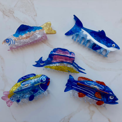 colorful fish shaped hair clips on a marble background