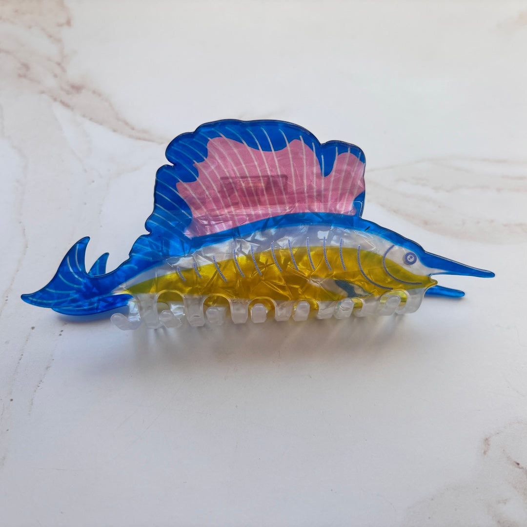 Colorful fish-shaped hair clip on a white surface