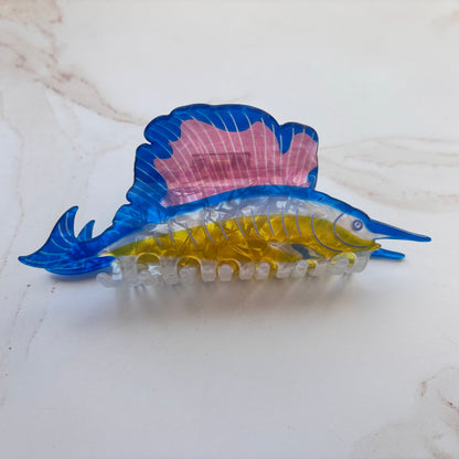 Colorful fish-shaped hair clip on a white surface
