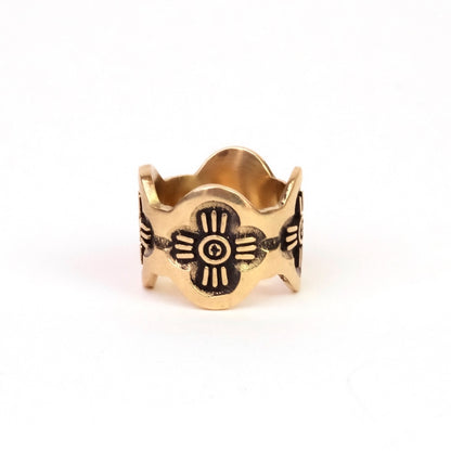 Brass ring with floral design on a white background