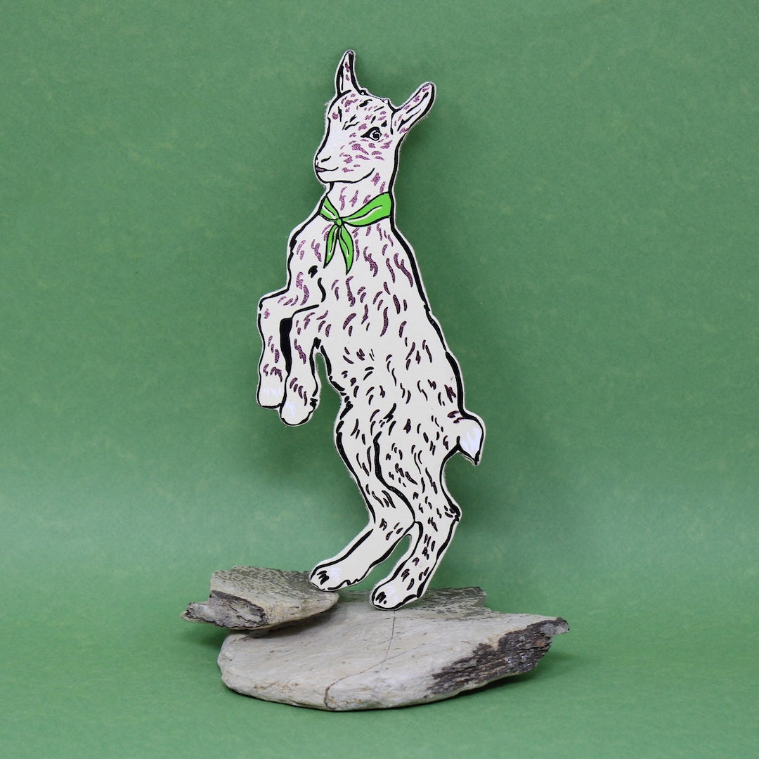 Cream goat shaped leather bookmark on a green background