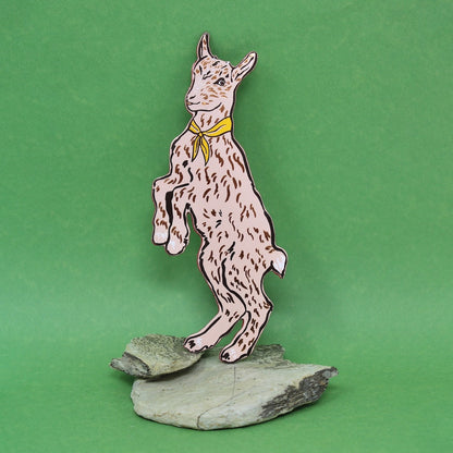 Pale pink goat shaped leather bookmark on a green background