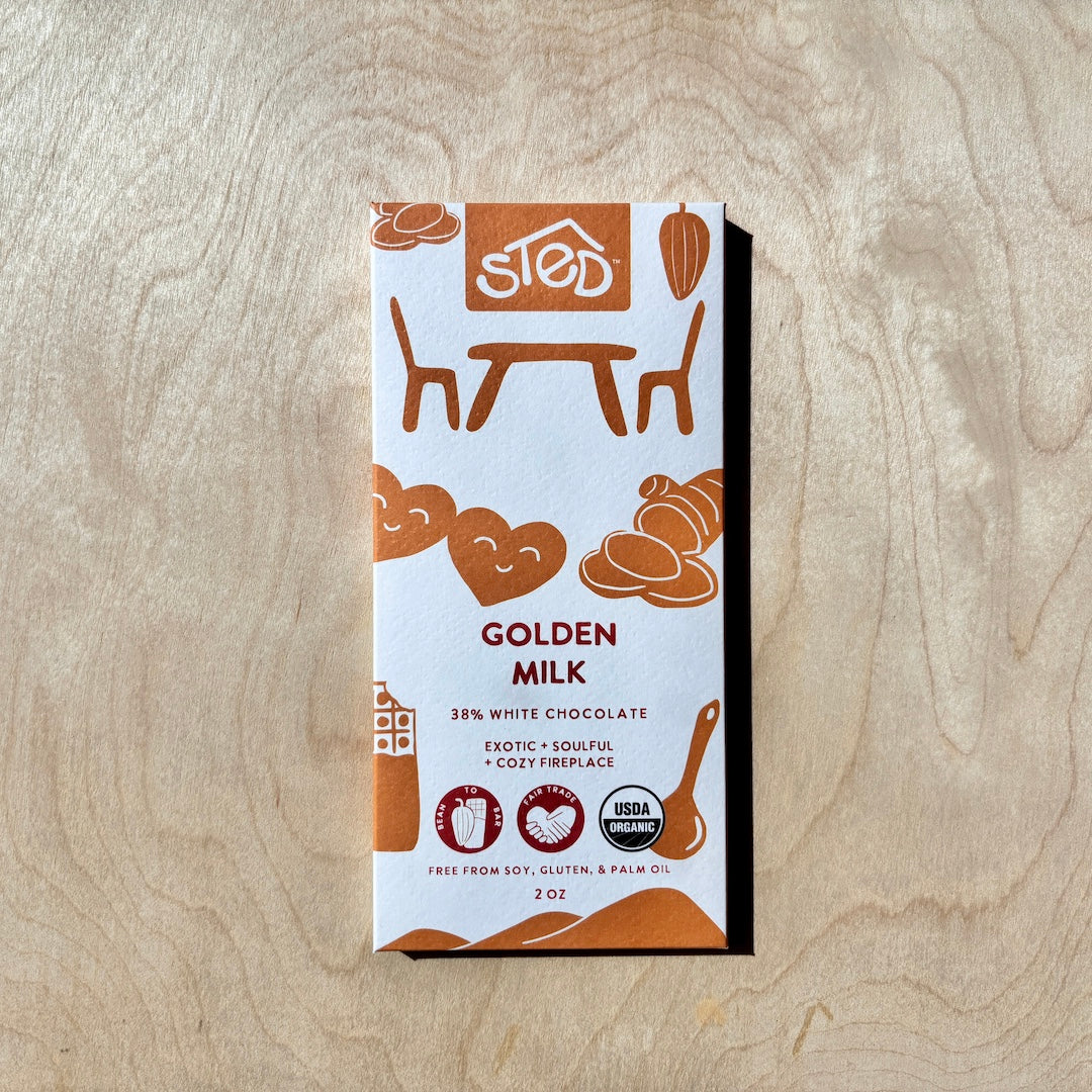 STED golden milk chocolate bar  in packaging on a wooden surface