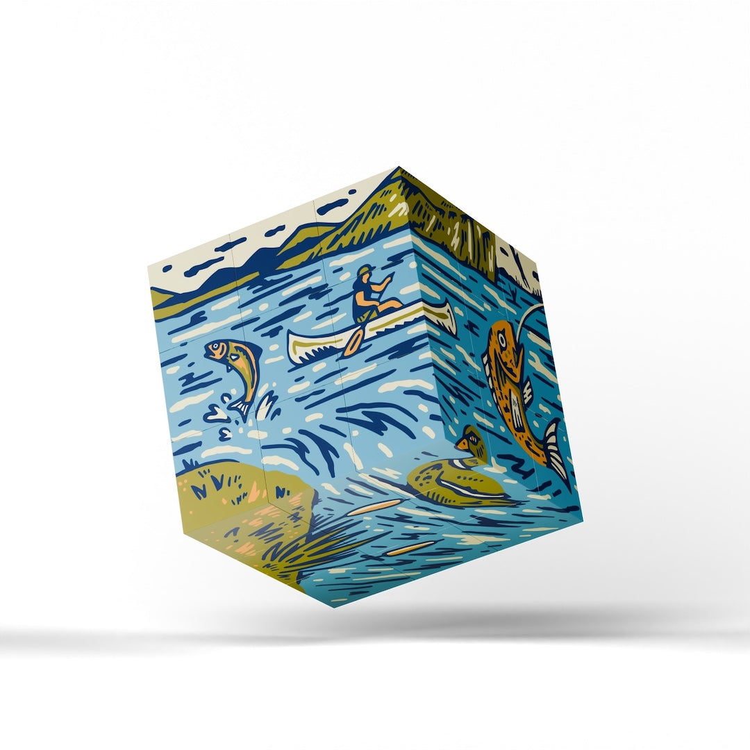 A floating cube-shaped product with a colorful nature illustration print, featuring blue water, fish, a canoe, and mountains, shown against a white background with a soft shadow.