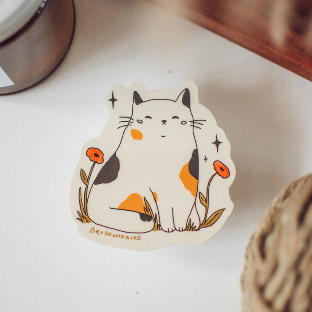Sticker of a cat with flowers on a white surface