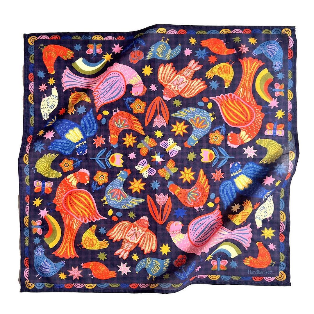 Colorful patterned bandana with birds and abstract designs on a dark background