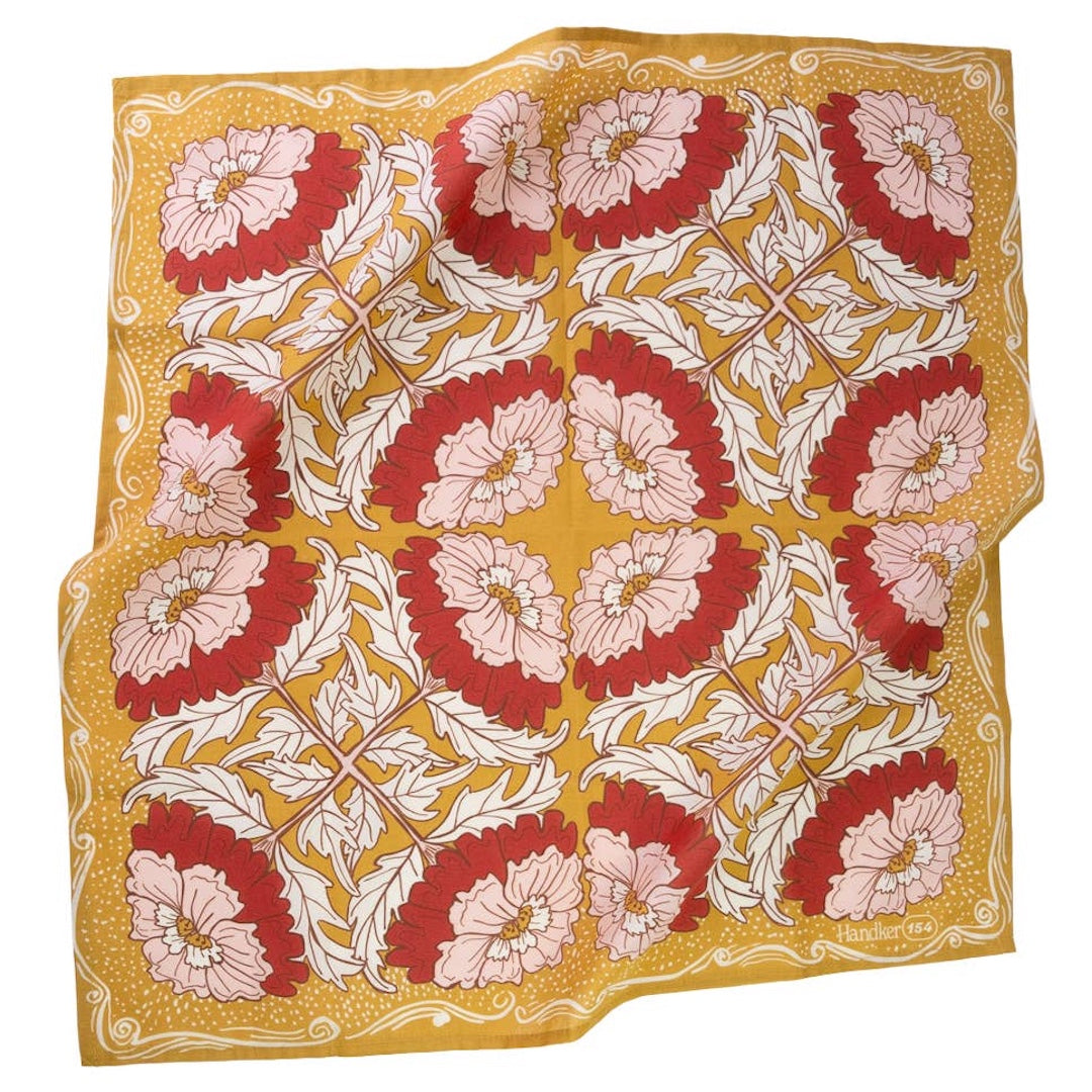 A bandana featuring a repeating floral pattern with red and light pink flowers, white leaves, and a mustard yellow background.