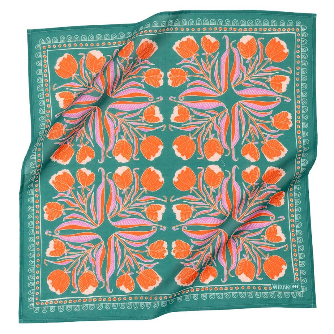 Floral patterned fabric with orange flowers on a green background