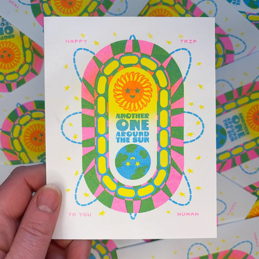 Colorful card with abstract design and text held by a hand on a multicolored background