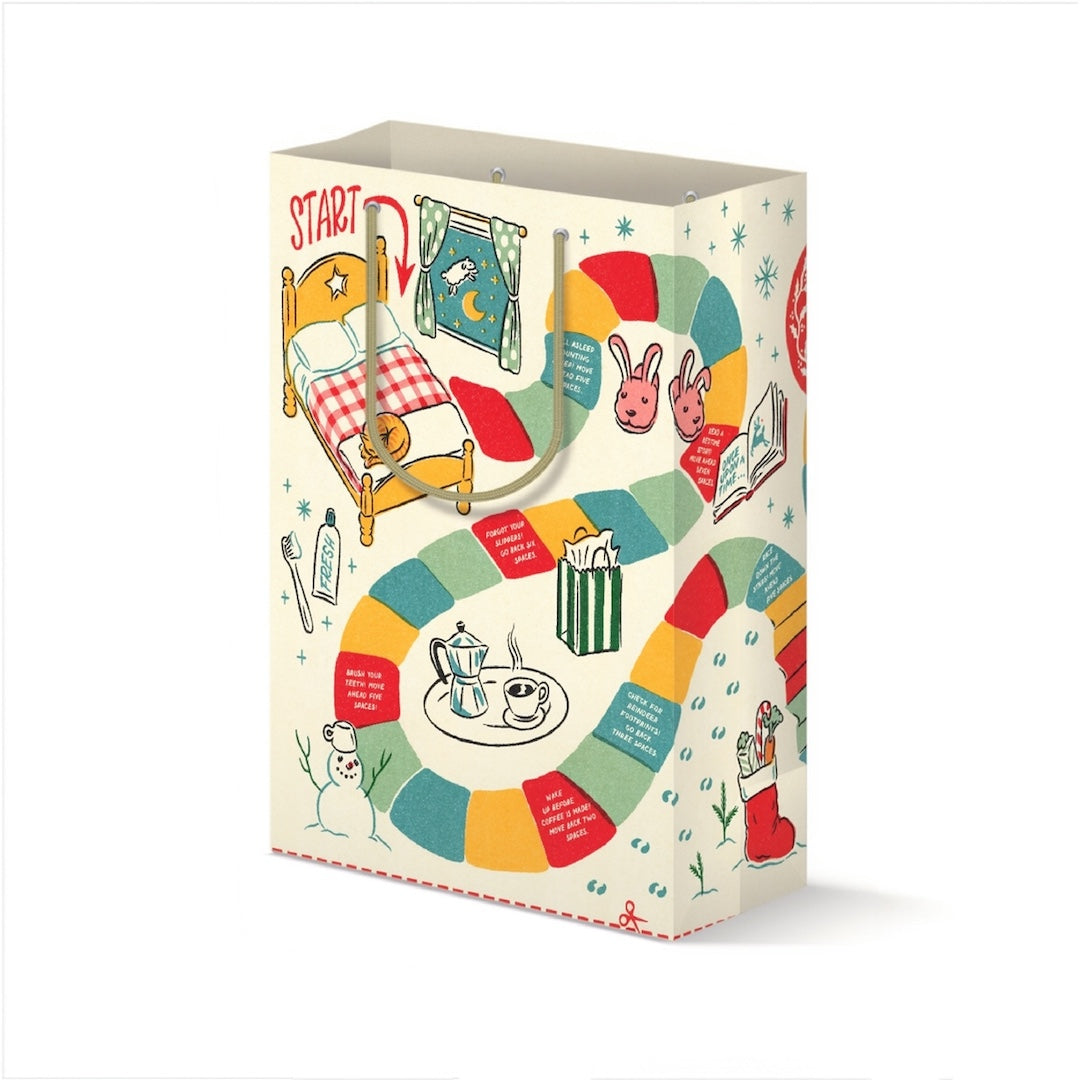 A decorative gift bag featuring a colorful Christmas-themed board game illustration with a winding path, holiday illustrations, and a red 'START' label on a white background.