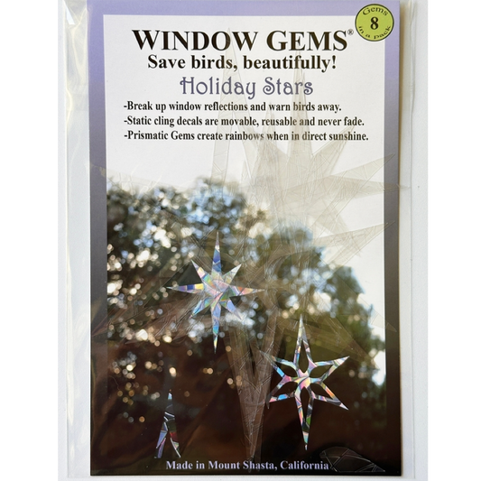 Window Gems 'Holiday Stars' suncatcher stickers in its clear plastic packaging, featuring a white and lavender label with product details and a demonstration photo of iridescent star decals.