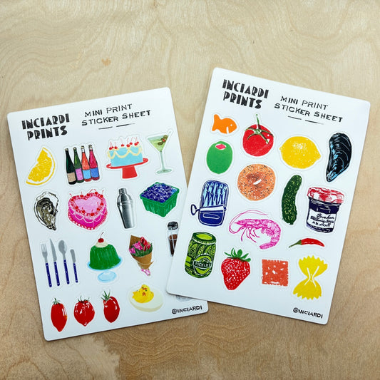 Two sticker sheets from Inciardi Prints featuring colorful food and drink illustrations, displayed on a light wood surface.