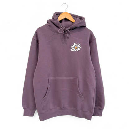 Purple hoodie with a white flower design on a hanger against a white background