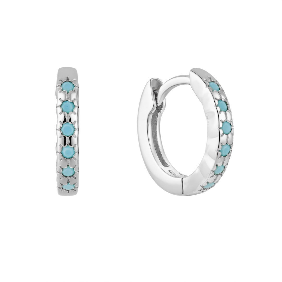 Silver huggie hoop earrings with turquoise stones on a white background
