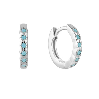 Silver huggie hoop earrings with turquoise stones on a white background