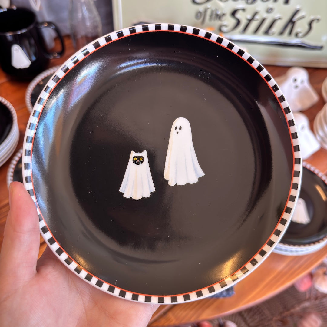 round black plate with a ghost and a cat under a sheet looking like a ghost 