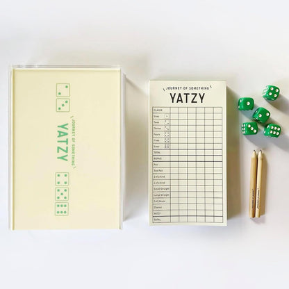 Yatzy game set with scorecard, dice, and pencil on a white background