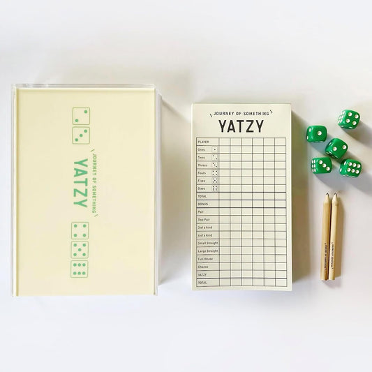 Yatzy game set with scorecard, dice, and pencil on a white background