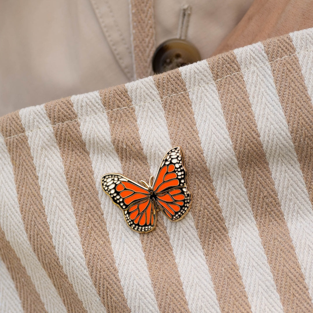 Butterfly pin on a striped fabric background