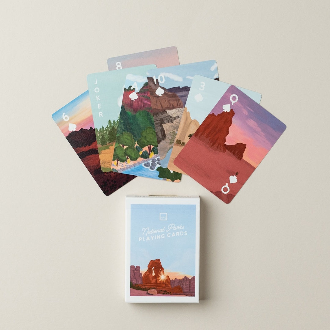 Set of playing cards with national park illustrations and a matching card box on a beige background