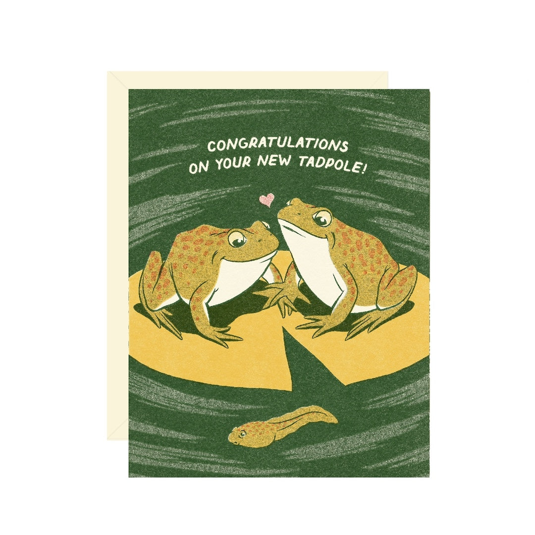 Greeting card with frogs and a tadpole on a green background. Text on card reads "congratulations on your new tadpole!"