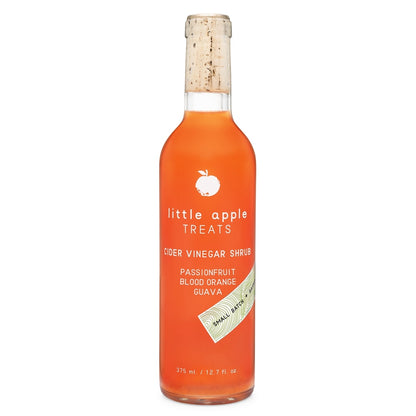 Bottle of 'little apple Treats' cider vinegar shrub with passionfruit, blood orange, and guava flavor on a white background.