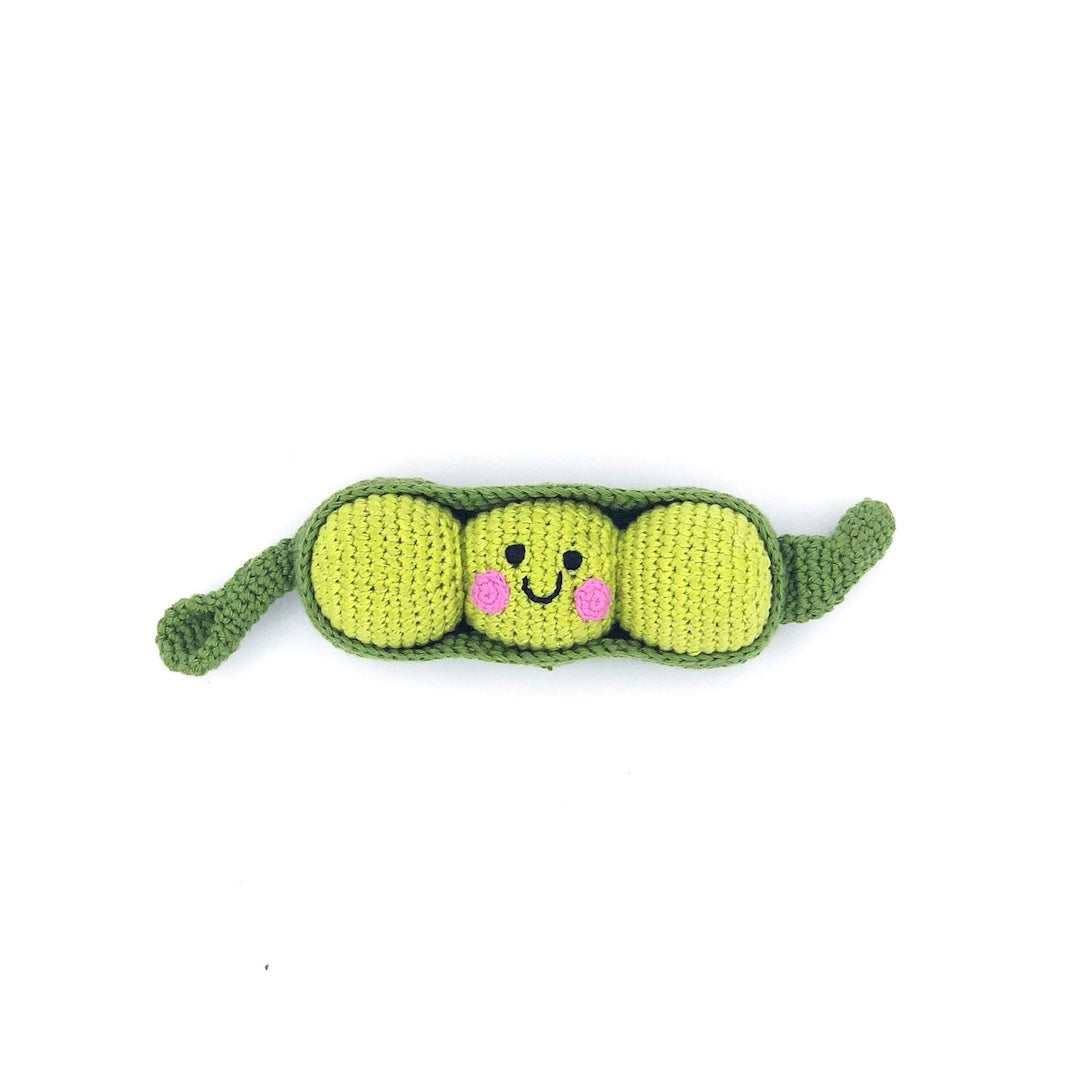 Crocheted toy shaped like a pea pod with a smiley face on a white background