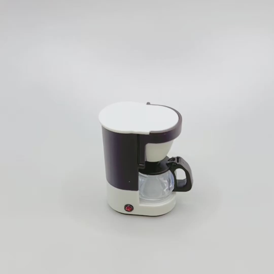 Video showing a miniature retro coffee maker. A hand reaches out to show that the coffee pot can be removed from the maker and the lid flaps open and closed. The hand then spins the coffee maker around so you can see the whole product, including the magnet on the back.