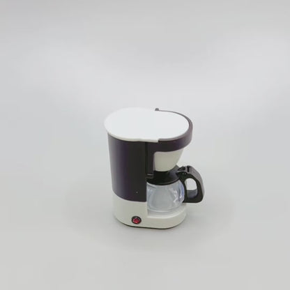 Video showing a miniature retro coffee maker. A hand reaches out to show that the coffee pot can be removed from the maker and the lid flaps open and closed. The hand then spins the coffee maker around so you can see the whole product, including the magnet on the back.