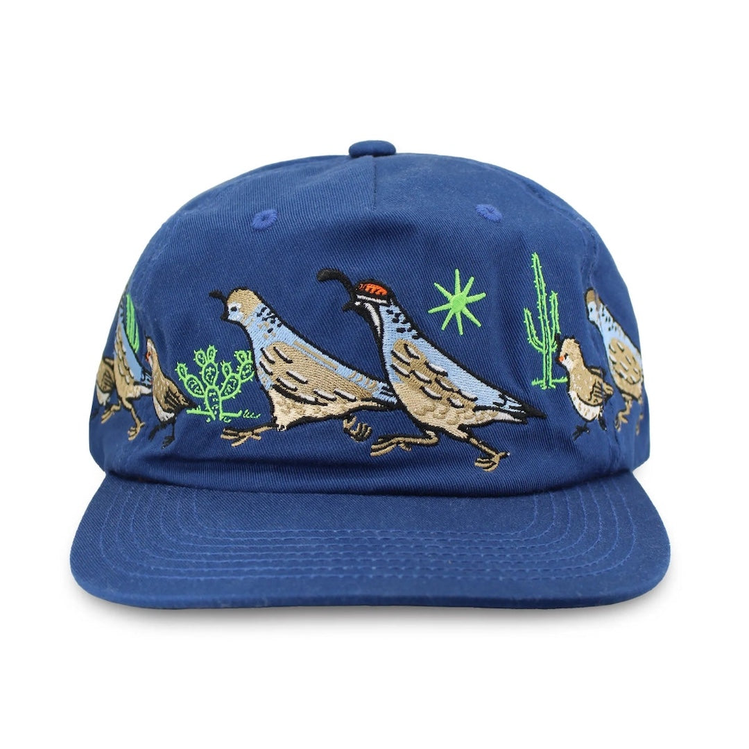 Blue cap with embroidered quails and cacti on a white background