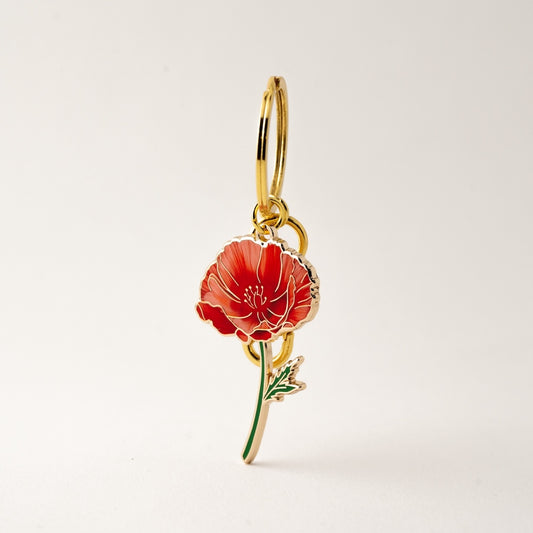 red poppy keychain/bag charm on a white background