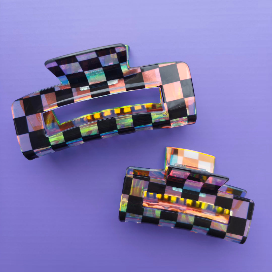 iridescent and black checkered hair clips on a purple background