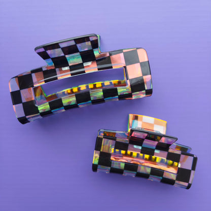 iridescent and black checkered hair clips on a purple background