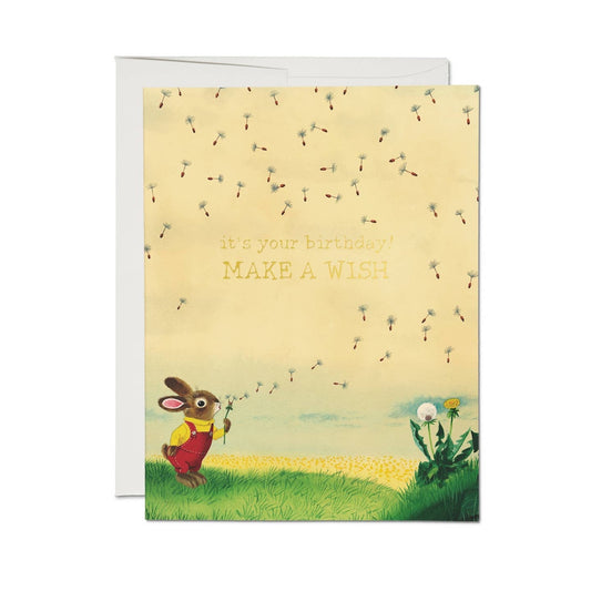 Greeting card with a cartoon rabbit holding dandelion seeds in a field
