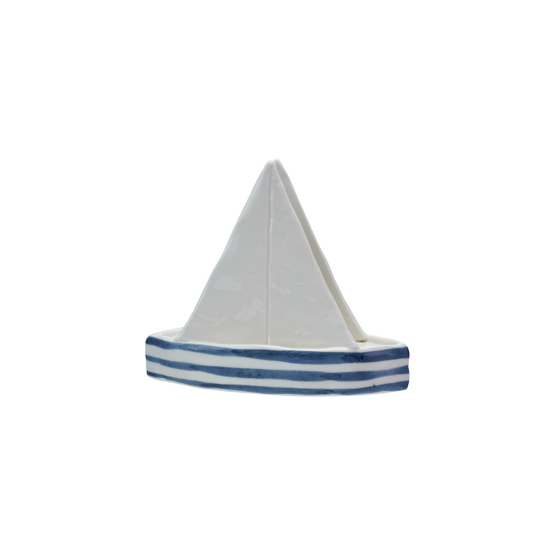 sailboat shaped napkin holder with a white sail and blue stripes on a white background