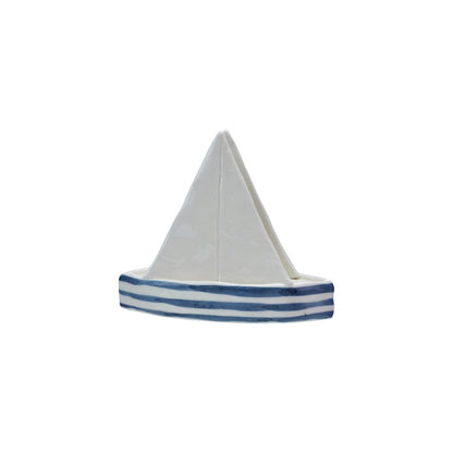 sailboat shaped napkin holder with a white sail and blue stripes on a white background