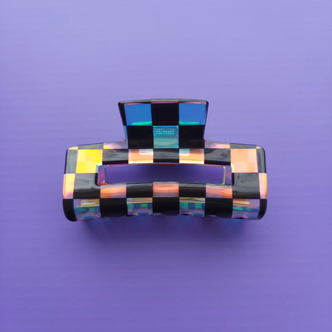 iridescent and black checkered hair clip on a purple background
