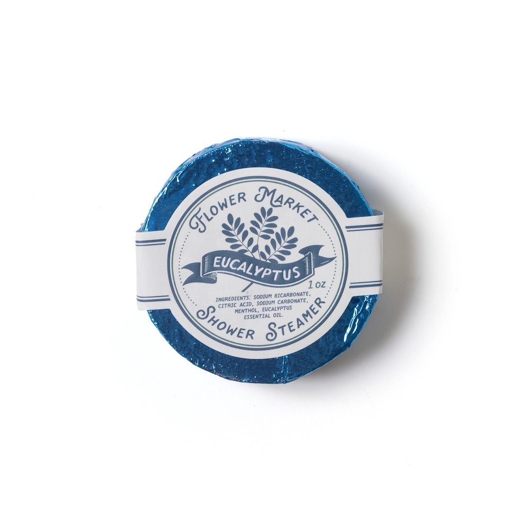 Round eucalyptus scented shower steamer with 'Flower Market' branding on a white background